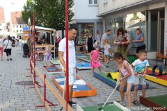 Kinder vergnügen sich beim Minigolf in der Marktstraße.